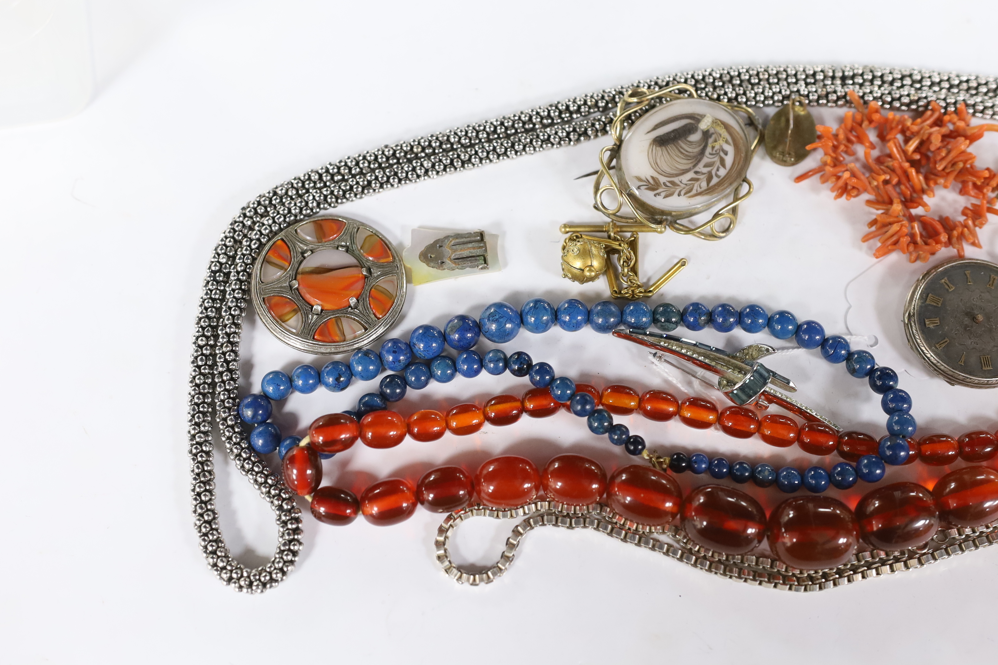Assorted jewellery including a graduated simulated amber bead necklace, coral branch necklace, white metal oval brooch, Victorian mourning brooch etc.